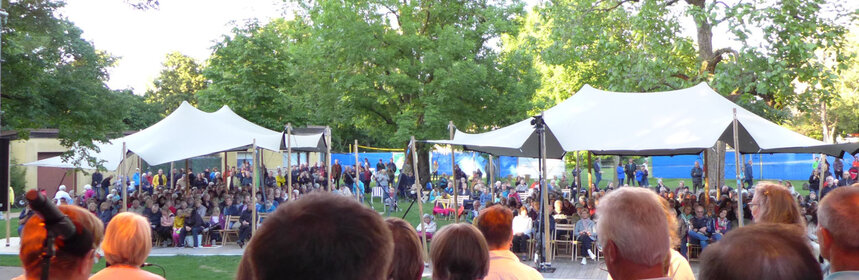 Kulturelle Veranstaltungen im Königsbad. Musiker auf der Bühne und Menschen im Publikum.