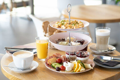 dekorativer kleiner gedeckter Frühstückstisch mit Speisen, Kaffee und Saft