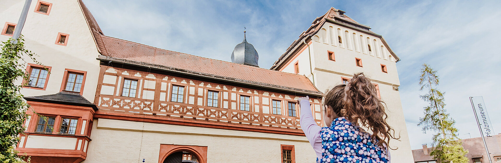 Mädchen zeigt mit dem Finger auf die Kaiserpfalz Forchheim