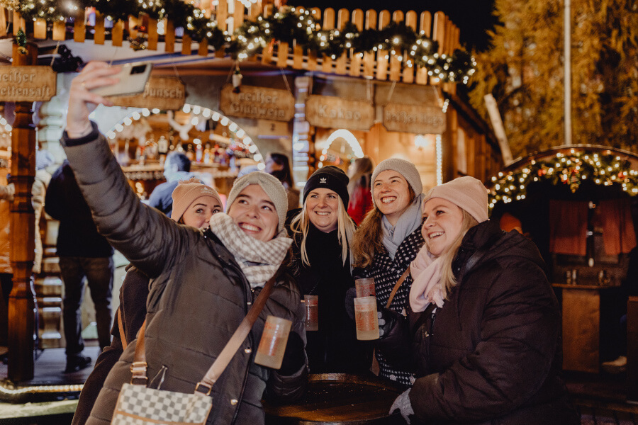 Vier junge Frauen am Forchheimer Weihnachtsmarkt machen ein Selfie.